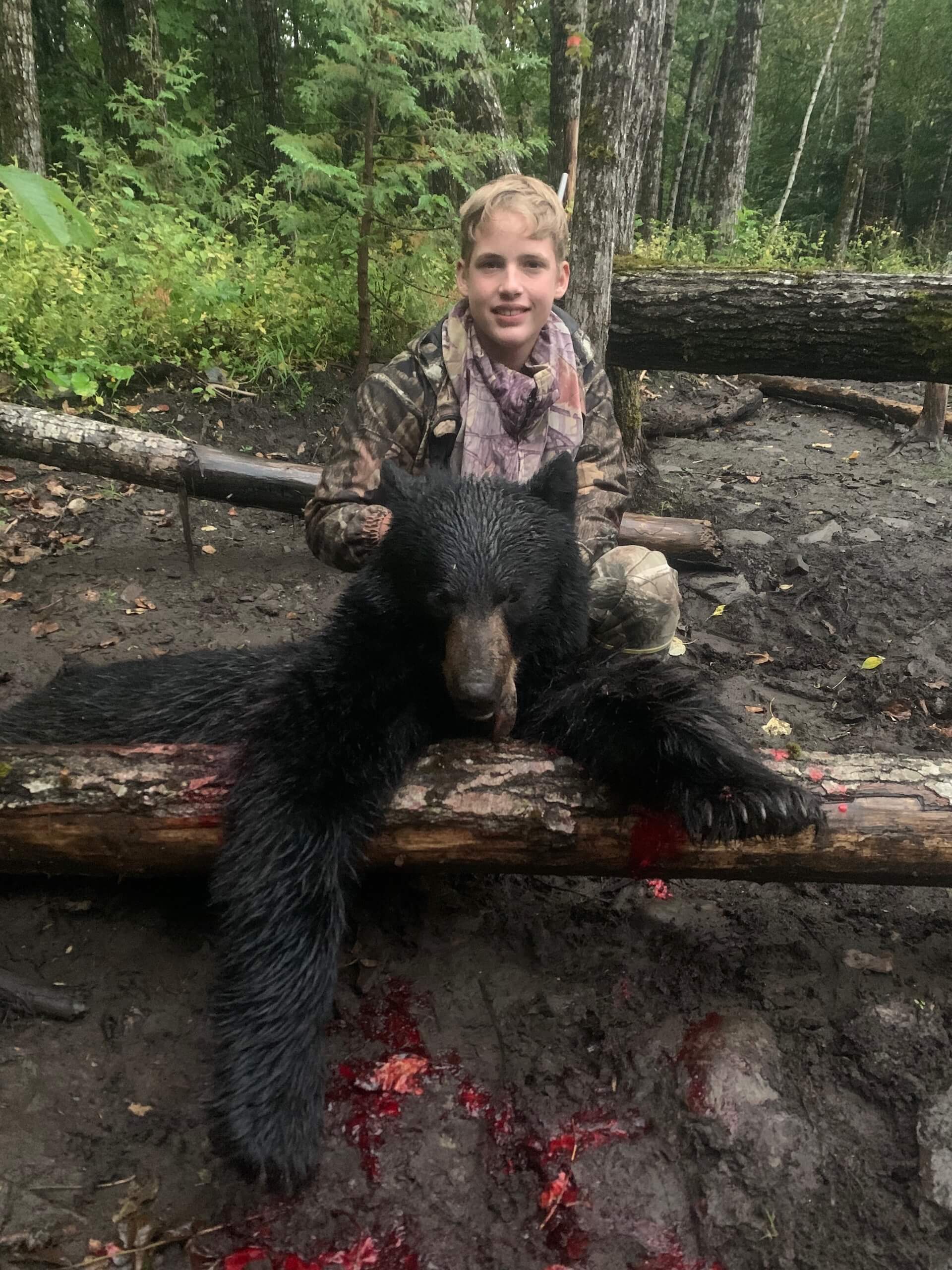 child with small harvested black bear