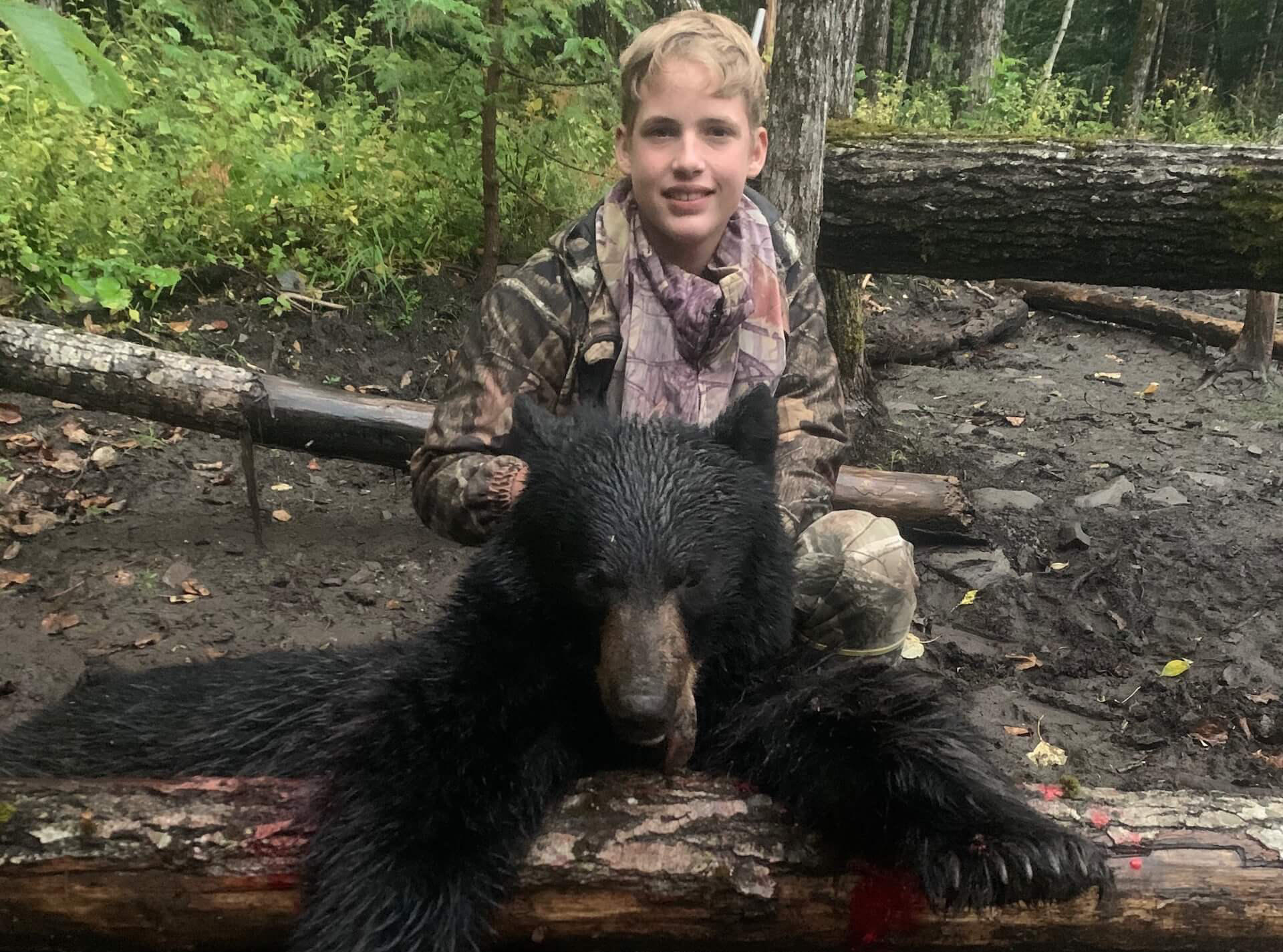 child with small harvested black bear