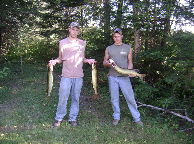 man in camo with bow and killed black bear cub