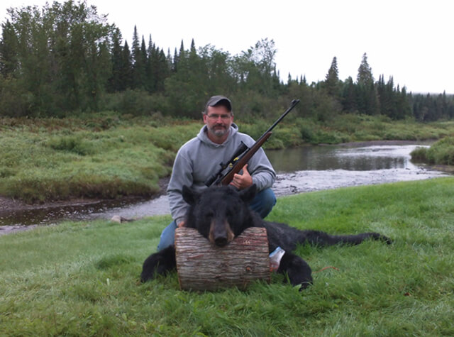 man starting to skin black bear