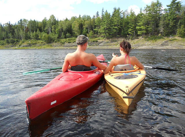 view of large river on hunting lodge property with deck and kayak