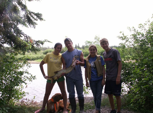 family with caught musky fish