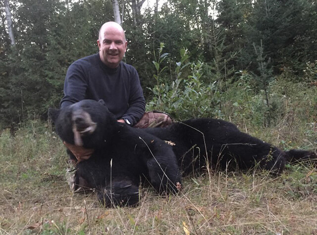four men posing with their rifles and killed black bears in a norther maine outfitter